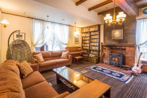 a living room with a couch and a fireplace at Hakuba Skala Inn in Hakuba