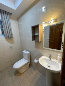 a bathroom with a toilet and a sink at Live Well Rwanda House in Kigali +40 photos