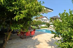 a patio with a table and chairs next to a pool at Villa Opera Kemer Müstakil Villa in Kemer