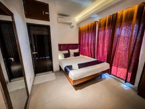 a bedroom with a bed and red curtains at Needs Bay Watch in Cox's Bazar