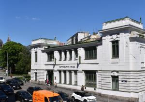 a white building with cars parked in front of it at vintage house - LGBTQ & female friendly in Vienna