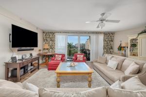 Una sala de estar con un sofá y un televisor. en St. Simons Grand #219, en Saint Simons Island