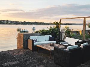 a patio with two couches and a table and water at Wellness Apartment Steckborn in Steckborn