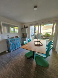 a dining room with a wooden table and green chairs at Wellness Apartment Steckborn in Steckborn