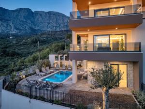 a villa with a swimming pool and a house at Blue Dream - La Luna Residence in Tučepi