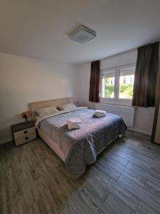 a bedroom with a bed with two towels on it at Apartament LUKE in Tîrgu Ocna