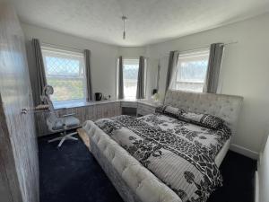 een slaapkamer met een bed, een stoel en ramen bij South Coast Guest Rooms With free onsite Parking in Poole