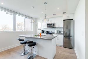 a white kitchen with a sink and a refrigerator at Bright & Inviting 3BR Apartment near High Park Nearest Intersection Indian Trail in Toronto +24 photos