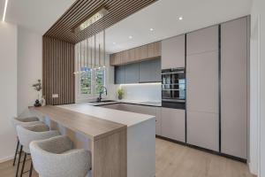 a kitchen with white cabinets and a wooden counter top at Blue Dream - La Luna Residence in Tučepi