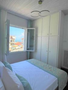 a bedroom with a large bed and a window at Aqua Mare Luxury Lodgings in Amfilochía
