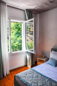 a bedroom with a bed and a large window at Aqua Mare Luxury Lodgings in Amfilochía