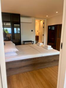 a bedroom with a large bed with white sheets at Aeraki Apartments in Kavála
