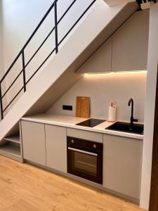 Una cocina con fregadero y escalera. en Aeraki Apartments, en Kavala