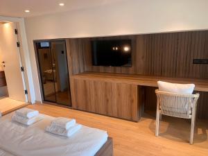 a living room with a tv and a chair and towels at Aeraki Apartments in Kavála