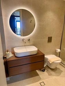a bathroom with a sink and a mirror and a toilet at Aeraki Apartments in Kavála +6 photos