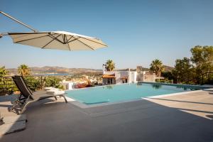 a swimming pool with a chair and an umbrella at Nicolas Villa in Anavissos