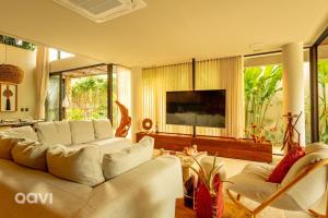 ein Wohnzimmer mit Couch und Flachbildfernseher in der Unterkunft Casa em condomínio beira mar Serena E1 by Qavi in Barra do Camaragibe