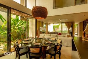 ein Esszimmer mit Tisch und Stühlen und einer Couch in der Unterkunft Casa em condomínio beira mar Serena E1 by Qavi in Barra do Camaragibe