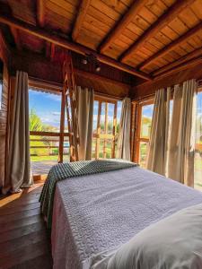 une chambre avec un lit dans une pièce avec des fenêtres dans l'établissement La Belle de Jour, à Majorlândia
