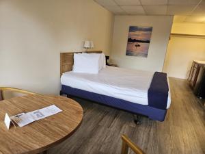 a hotel room with a bed and a table at Otter Creek Inn in Alexandria Bay