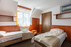 a hotel room with two beds and a window at Dom Wczasowy Jędrol - Jacuzzi & Basen in Zakopane +170 photos