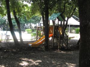 un parco giochi con scivolo in un parco alberato di illicini stabilimento balneare e albergo a Maratea