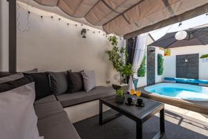 ヴィルにあるTiny Pool Houseのリビングルーム(ソファ付)、スイミングプールが備わります。