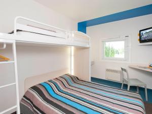 Habitación pequeña con litera y escritorio. en Hotel First Eco Dieppe, en Dieppe