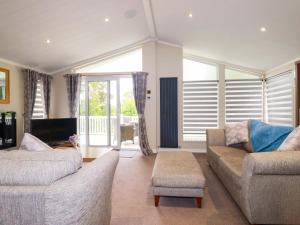a living room with two couches and a tv at The Maples 44 in St Austell