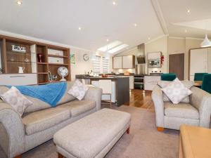 a living room with two couches and a kitchen at The Maples 44 in St Austell