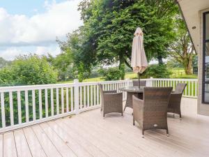 a patio with a table and chairs and an umbrella at The Maples 44 in St Austell