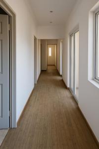 Un pasillo vacío con paredes blancas y pisos de madera. en Virgo Hostels, en Gaborone