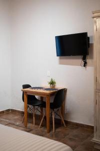 ein Tisch mit zwei Stühlen und ein Fernseher an einer Wand in der Unterkunft loft Diego en San Cristóbal de las Casas in San Cristóbal de las Casas