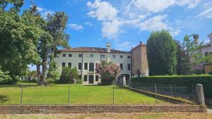 una gran casa blanca con una valla delante en Dimora Serenissima, en Mira
