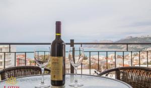 a bottle of wine sitting on a table with two wine glasses at Lotos - stan 318 in Dobra Voda