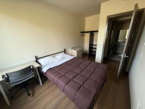 a bedroom with a bed and a desk and a chair at Residence & Conference Centre - Kelowna in Kelowna