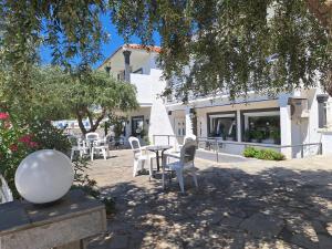 eine Terrasse mit Stühlen und einem Tisch vor einem Gebäude in der Unterkunft Euro Park Hotel in Astris