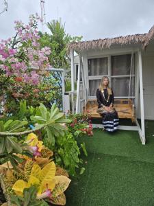 a woman sitting on a swing in a garden at Rooftop Rooms in Male City