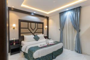 una camera da letto con un grande letto con tende blu di جاردنيا بارك الروابي Gardenia park Al Rawabi a Quwayzah Altre 104 foto