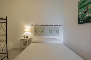 a white bedroom with a bed and a lamp at Design Villetta by Propertize in Villasimius