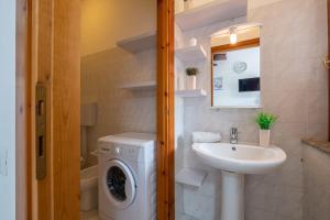 a bathroom with a washing machine and a sink at Design Villetta by Propertize in Villasimius