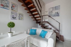 a white living room with a white couch and stairs at Design Villetta by Propertize in Villasimius