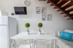 a white dining room with a white table and chairs at Design Villetta by Propertize in Villasimius +19 photos
