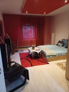 a bedroom with a bed and a table in front of a window at Apartament cu 2 dormitoare și terasa Valentin, Iulius Mall in Timişoara