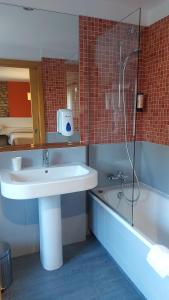 a bathroom with a sink and a shower and a tub at Posada Giraldilla in Liérganes