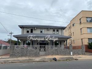 una casa con una valla delante de un edificio en Franque Lodge, en Durban