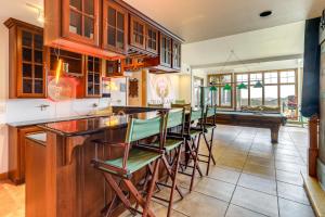 a kitchen with a bar with green bar stools at 366 Shared Acres, Lake Access: Ozark Getaway! in Fairfield Bay