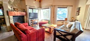 Una sala de estar con dos sofás y una chimenea. en Casa Barrio La Colina 15 pax, en San Carlos de Bariloche