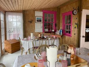 ein Esszimmer mit zwei Tischen und rosa Schränken in der Unterkunft La Forillonne in Gaspé