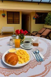 a breakfast of eggs and croissants on a table at La Rosario Hotel in Quito